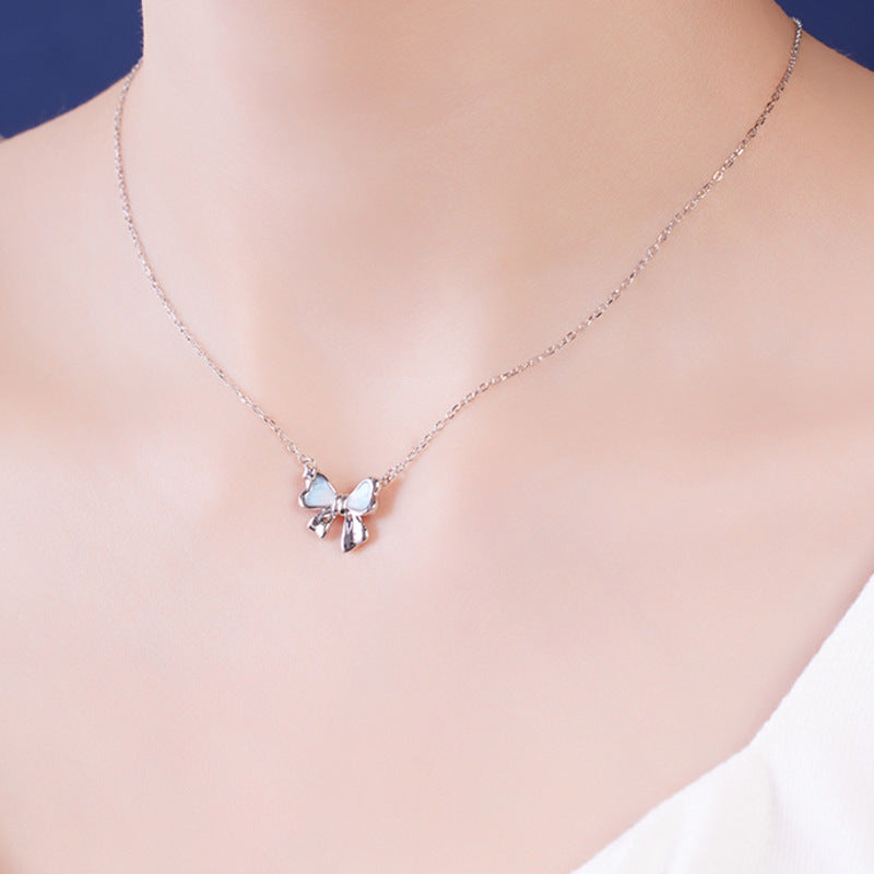 Model wearing gradient enamel bow necklace at collarbone