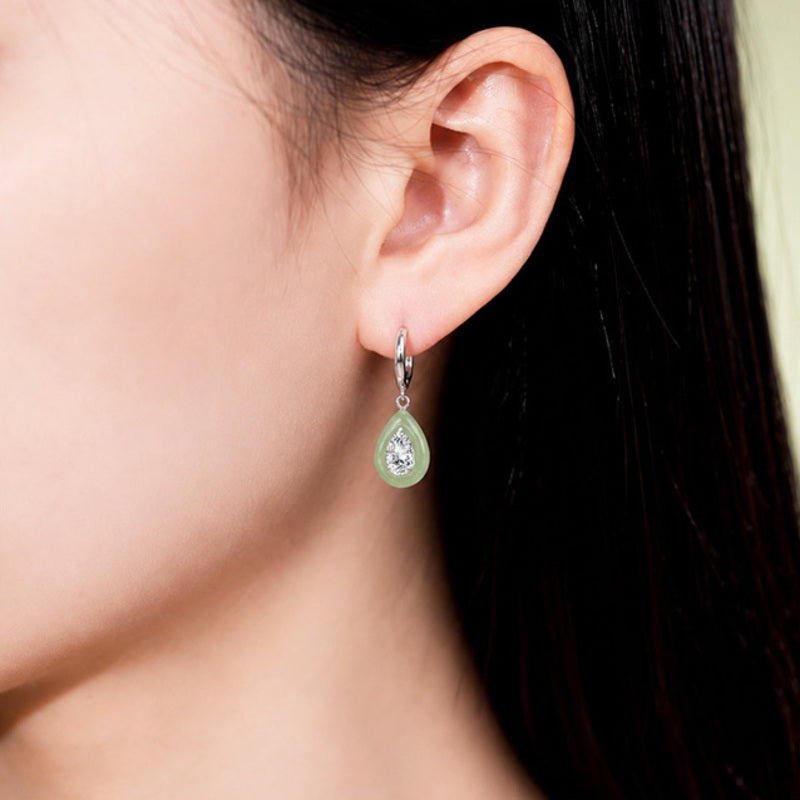 Woman wearing a greenish-white nephrite jade teardrop earring