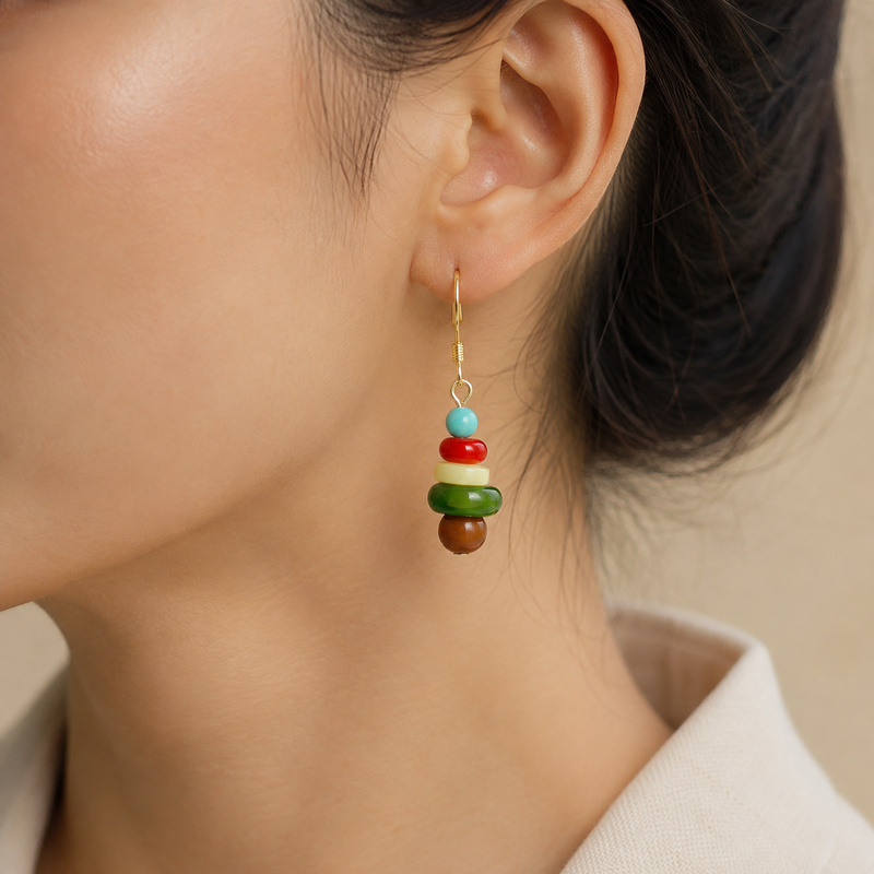 Five-stone gemstone drop earring worn on an adult model