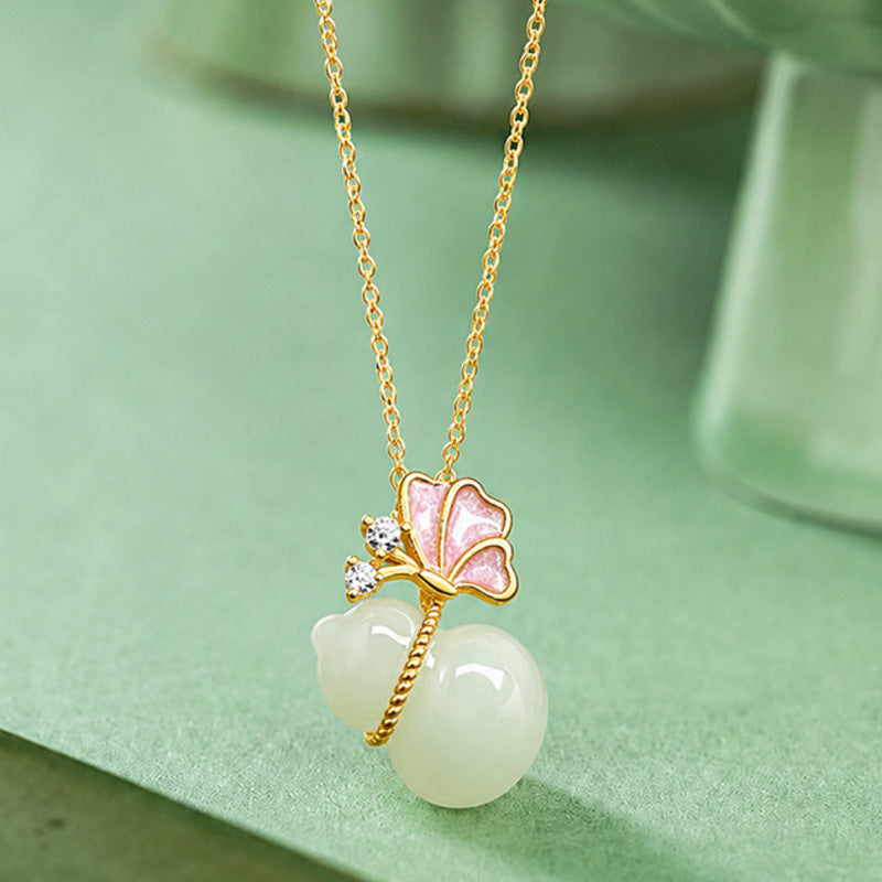 Hetian jade butterfly gourd necklace on green background