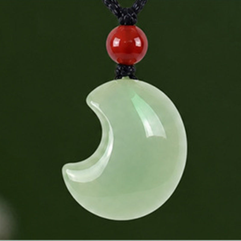 Close view of pale green Hetian jade crescent moon pendant
