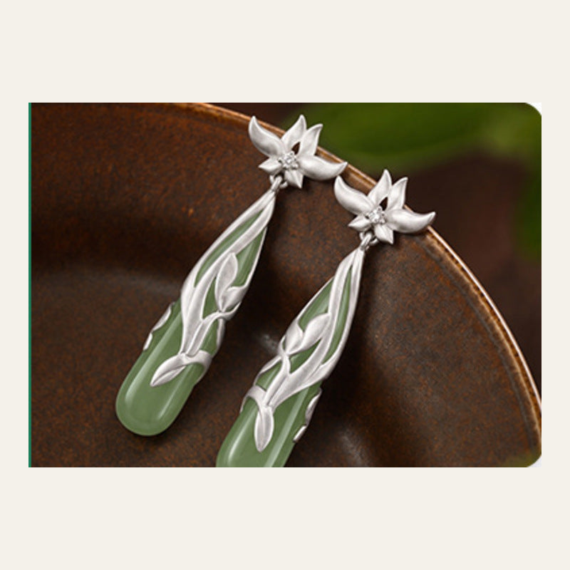 Angled view of Hetian jade magnolia earrings pair