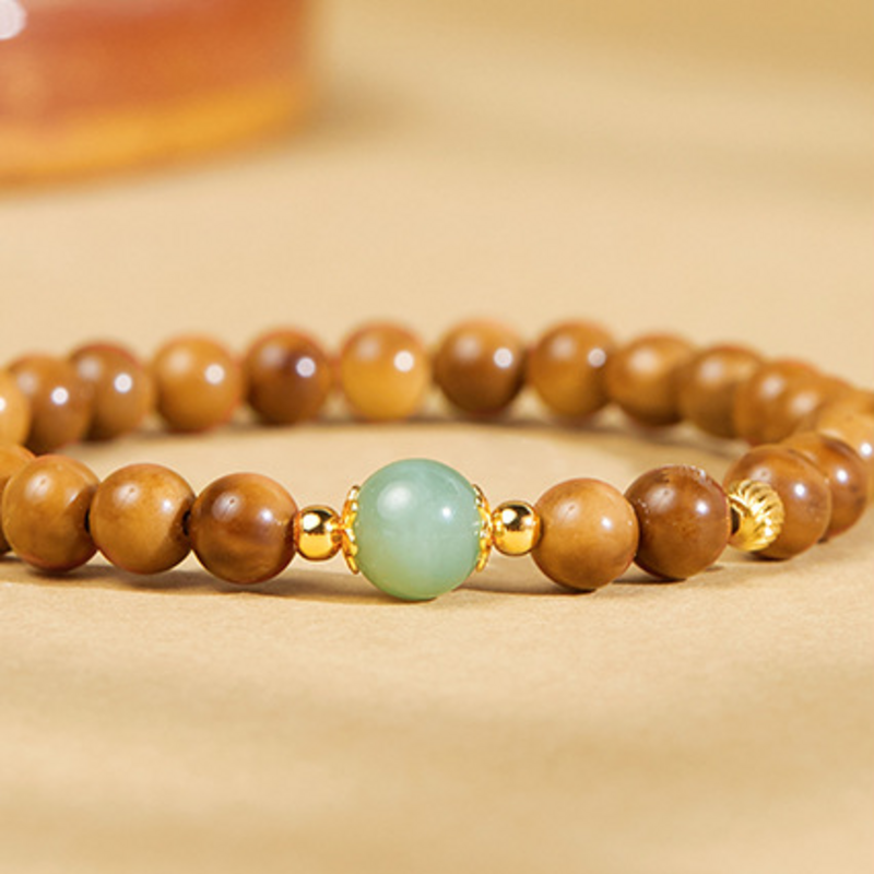 Close detail of pale green nephrite bead and polished Kuka beads