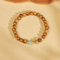 Kuka bead bracelet with centered green nephrite jade on warm backdrop