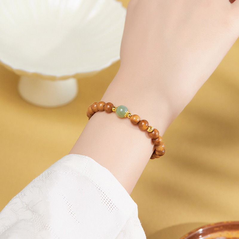 Woman wearing Kuka and nephrite jade elastic bracelet on wrist