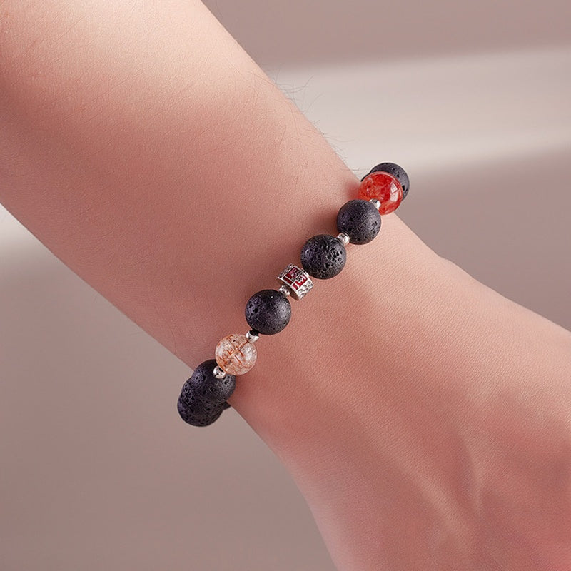 Lava stone and red inclusion quartz bracelet worn on wrist