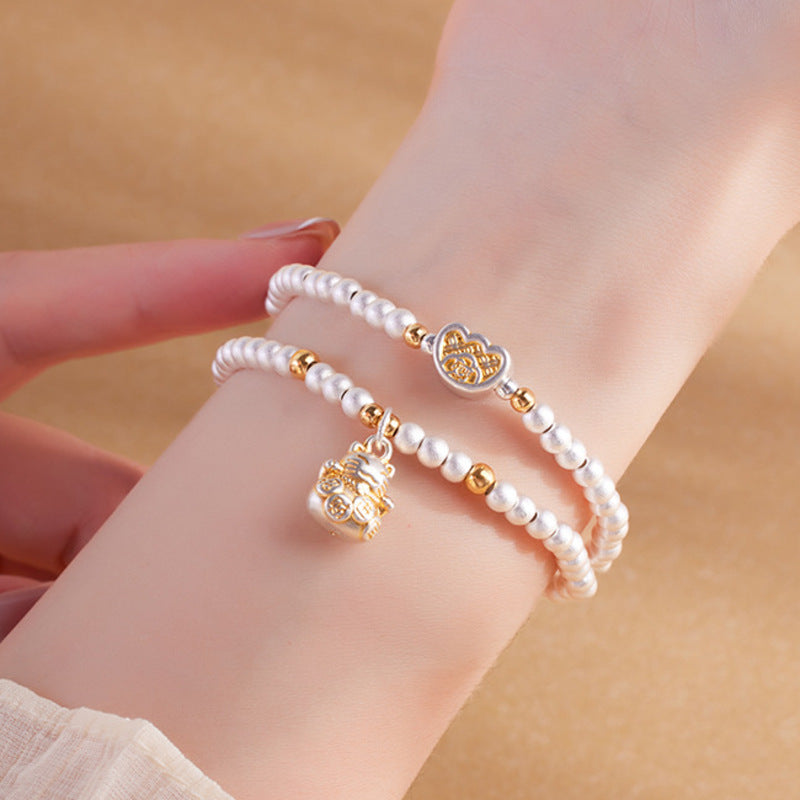 Lucky cat silver bracelet worn on a softly lit wrist