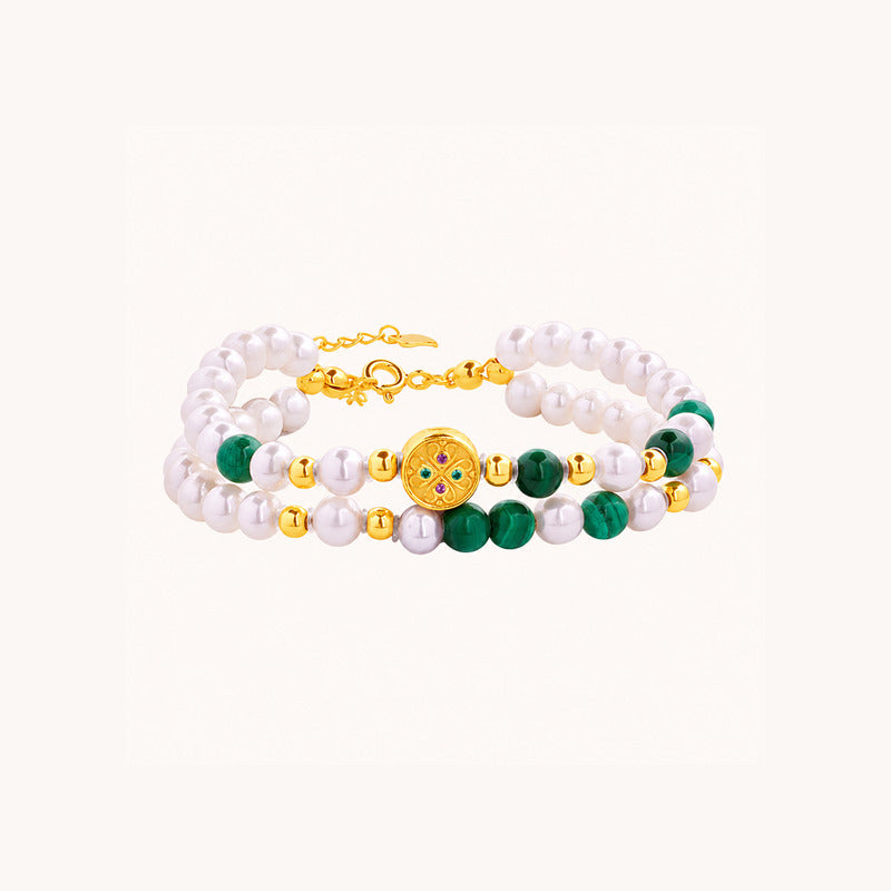 Malachite and freshwater pearl bracelet on a clean light background