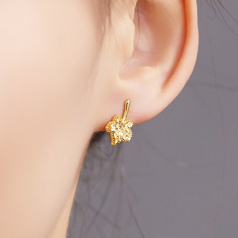 Supplier model wearing maple leaf stud earring, close-up