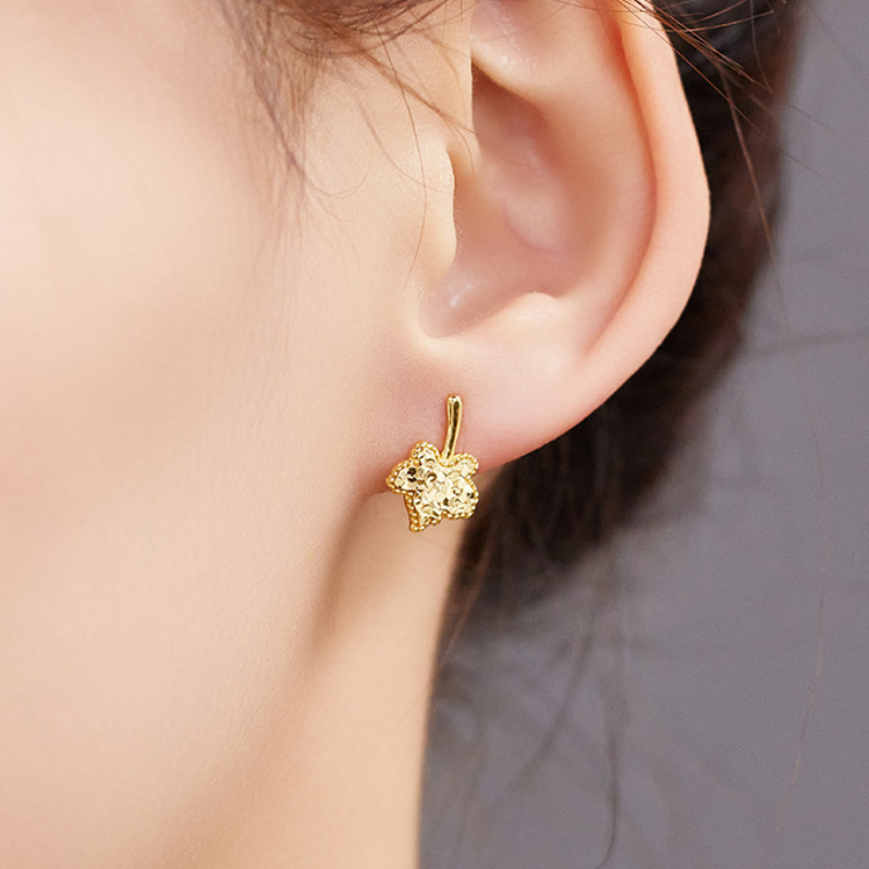 Maple leaf stud earring worn against the ear
