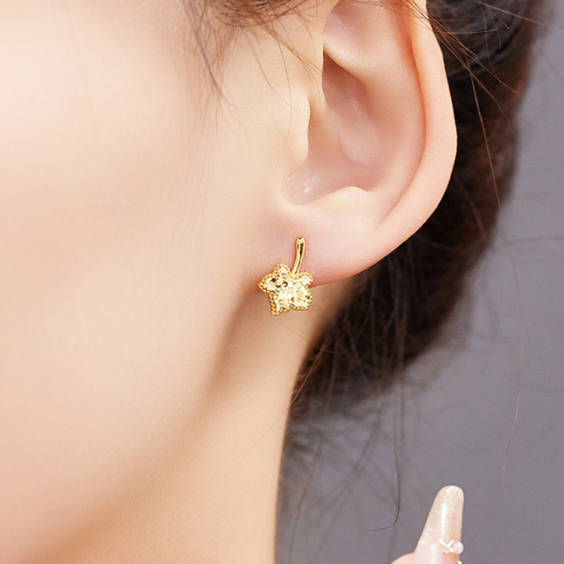 Maple leaf stud worn by the supplier model with hand nearby