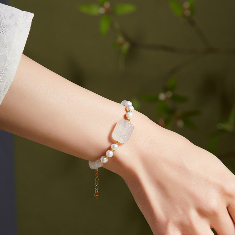White chalcedony and pearl bracelet worn on wrist outdoors