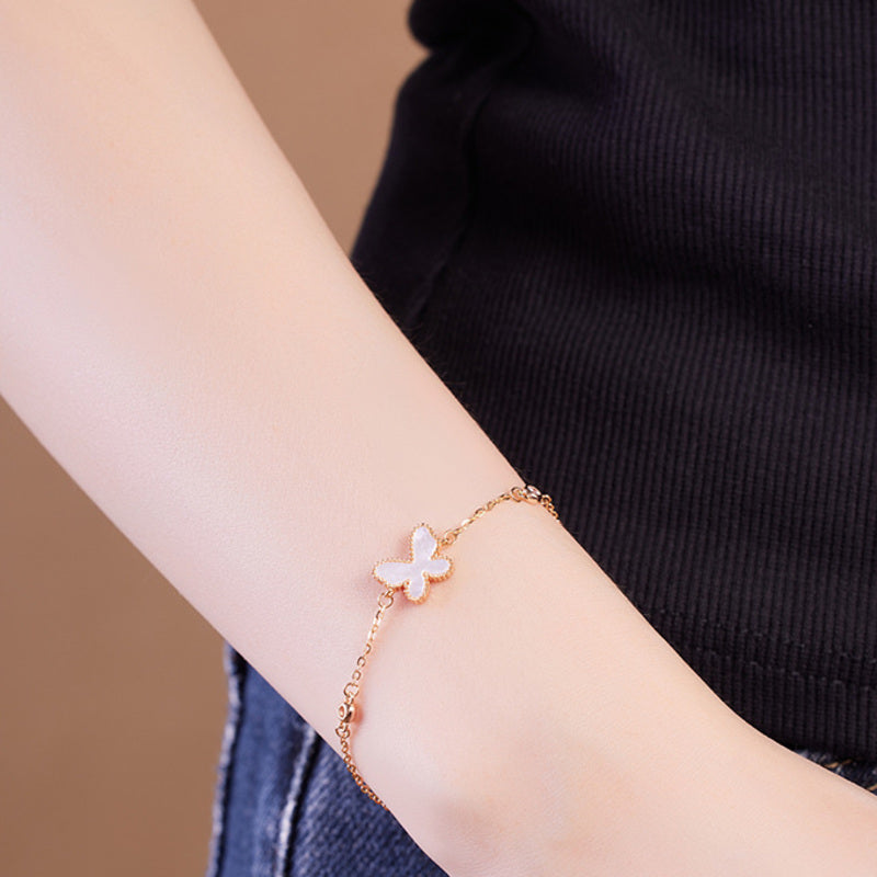 Mother-of-pearl butterfly bracelet styled with a black sleeveless top