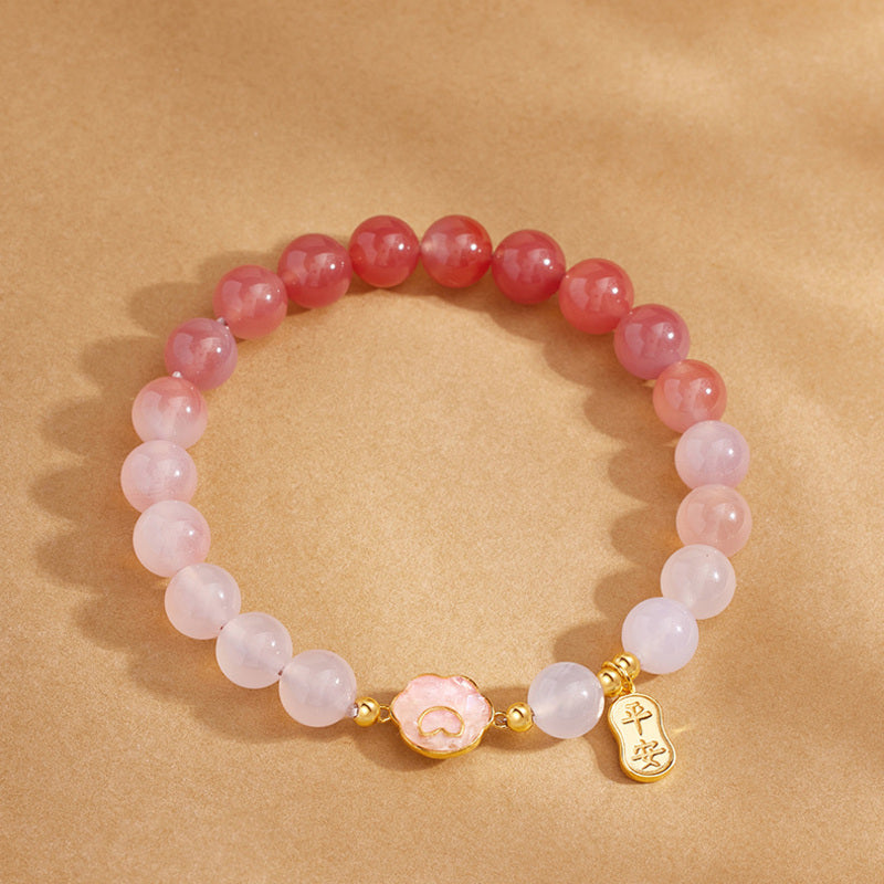 Gradient crimson agate bracelet with cat paw centerpiece top view
