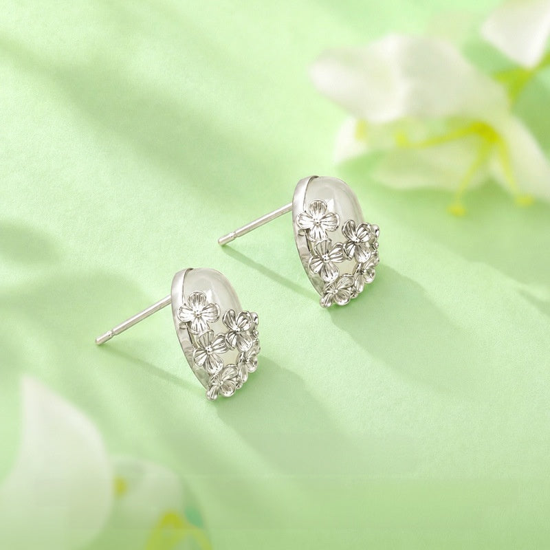 Nephrite jade flower stud earrings side view on soft green fabric