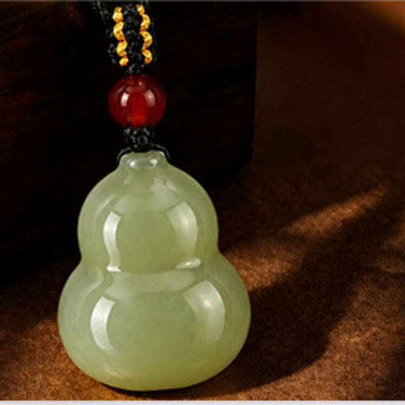 Close view of nephrite jade gourd pendant and red agate bead