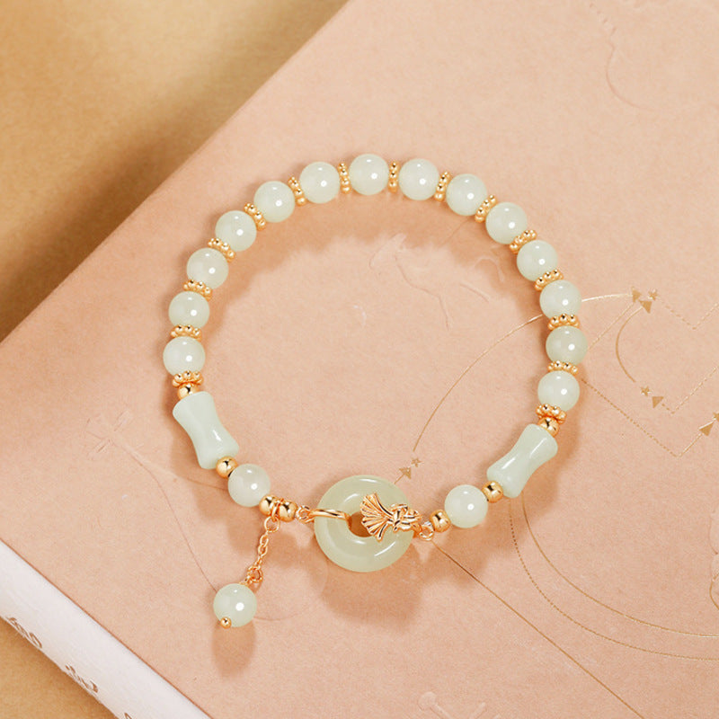 Nephrite jade peace buckle bracelet with bamboo beads on a peach background