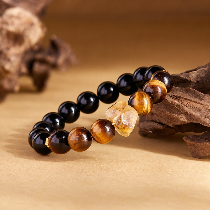 Yellow quartz centerpiece and tiger eye beads resting against textured wood
