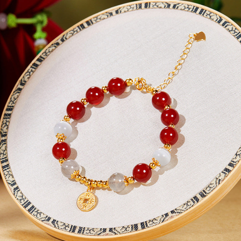 Single red agate bracelet with peace coin on embroidered display hoop