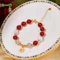 Single red agate bracelet with peace coin on embroidered display hoop