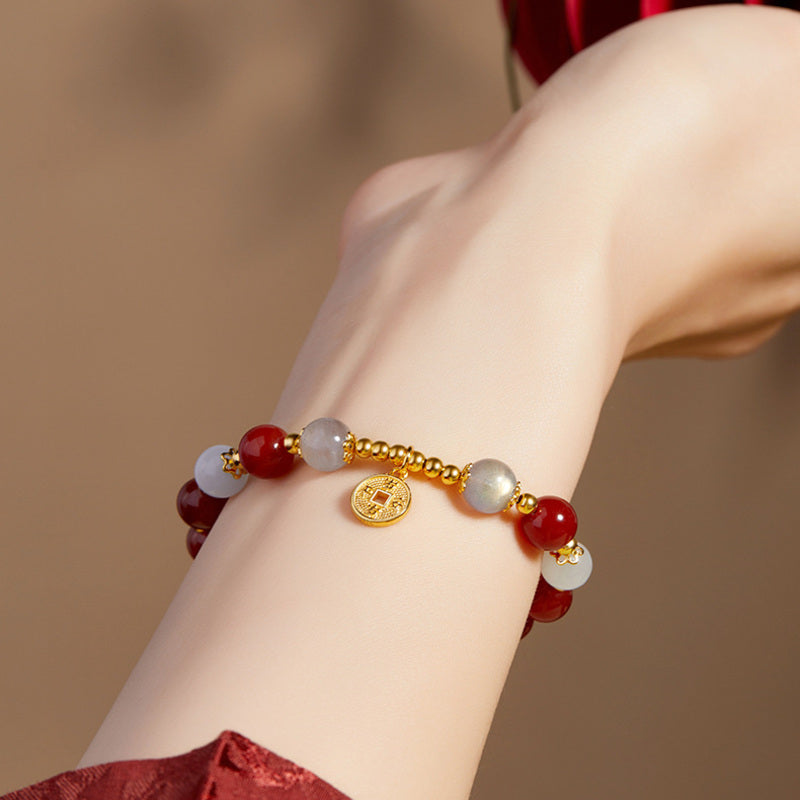 Red agate and gray moonstone peace coin bracelet worn on wrist