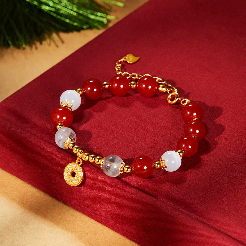 Adjustable red agate bracelet with round coin charm on red fabric