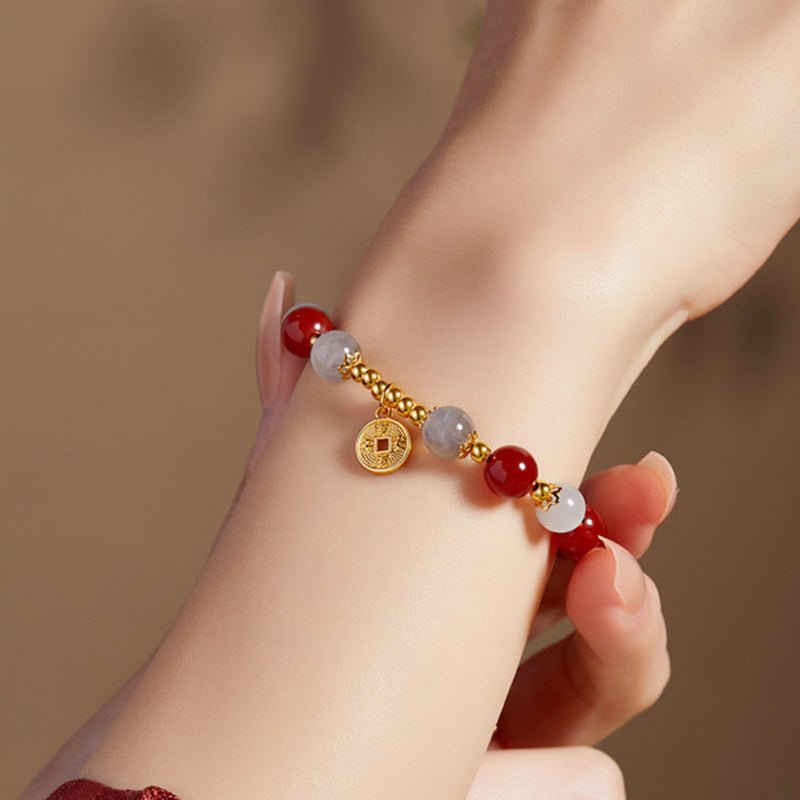 Close wrist view of S925 silver coin charm and gemstone bracelet