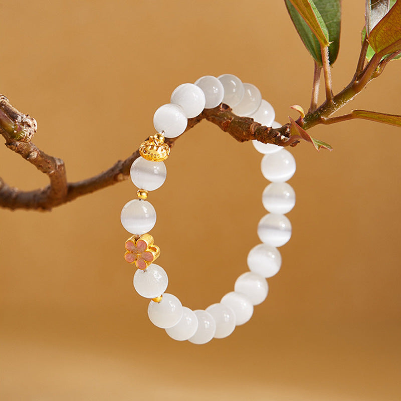 Cat-eye glass bracelet hanging from a branch