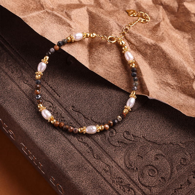 Pietersite and six freshwater pearls on warm brown leather