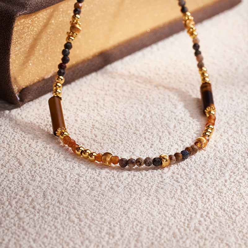 Pietersite and Orange Garnet necklace on a warm textured background