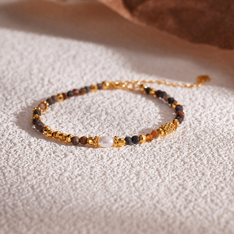 Pietersite and freshwater pearl bracelet on warm textured fabric