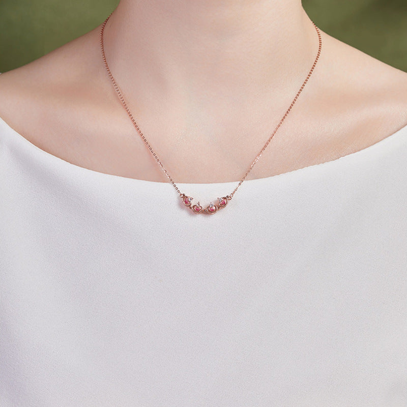 Model wearing the unfolded magnetic clover necklace