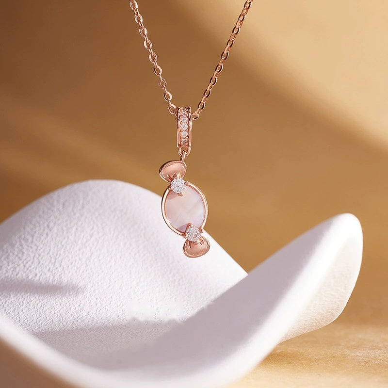 Pink mother-of-pearl candy necklace on warm sculptural background