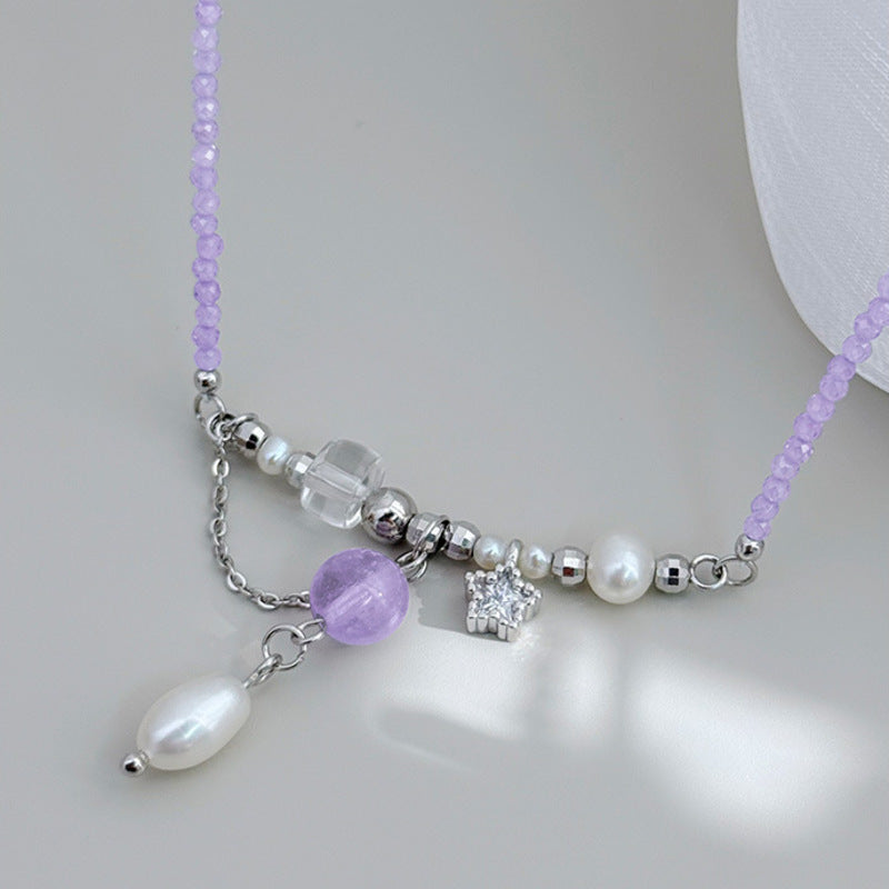 Amethyst and freshwater pearl necklace arranged on gray surface