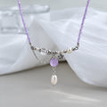 Amethyst pearl necklace on soft white fabric background