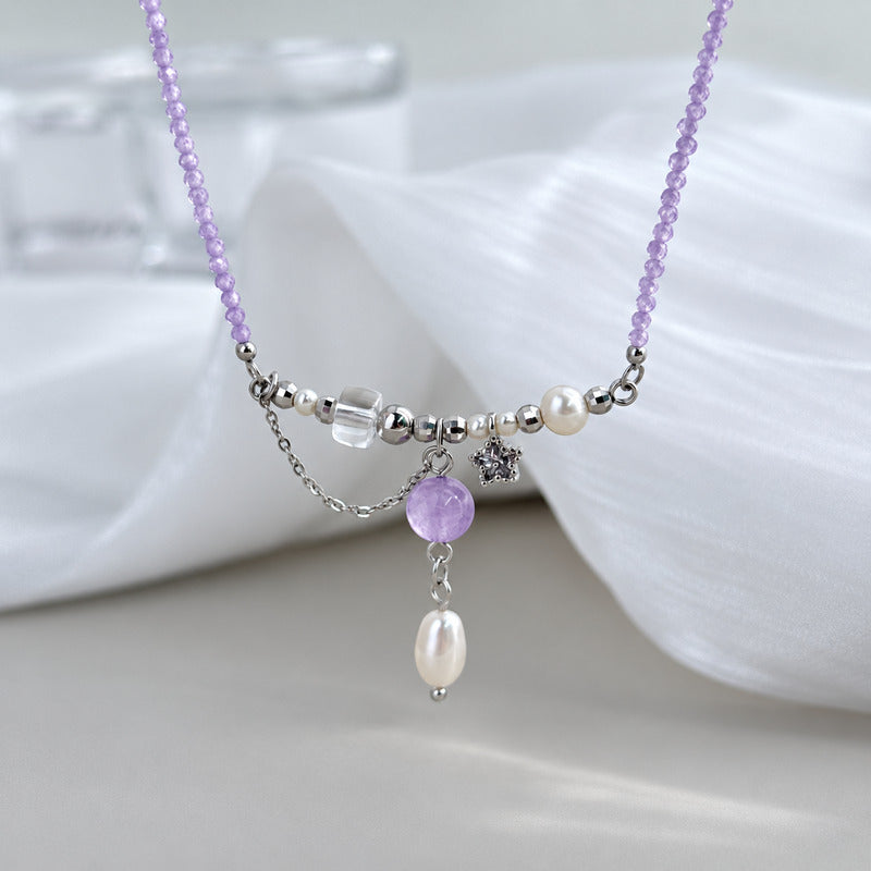 Amethyst pearl necklace on soft white fabric background