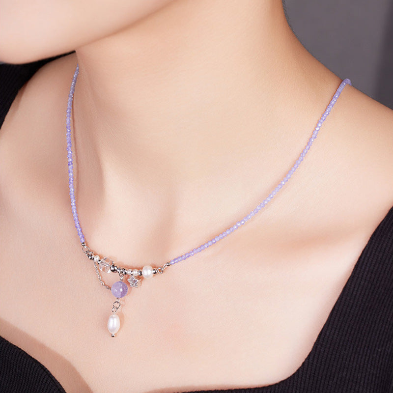 Woman wearing pale purple amethyst and pearl pendant necklace