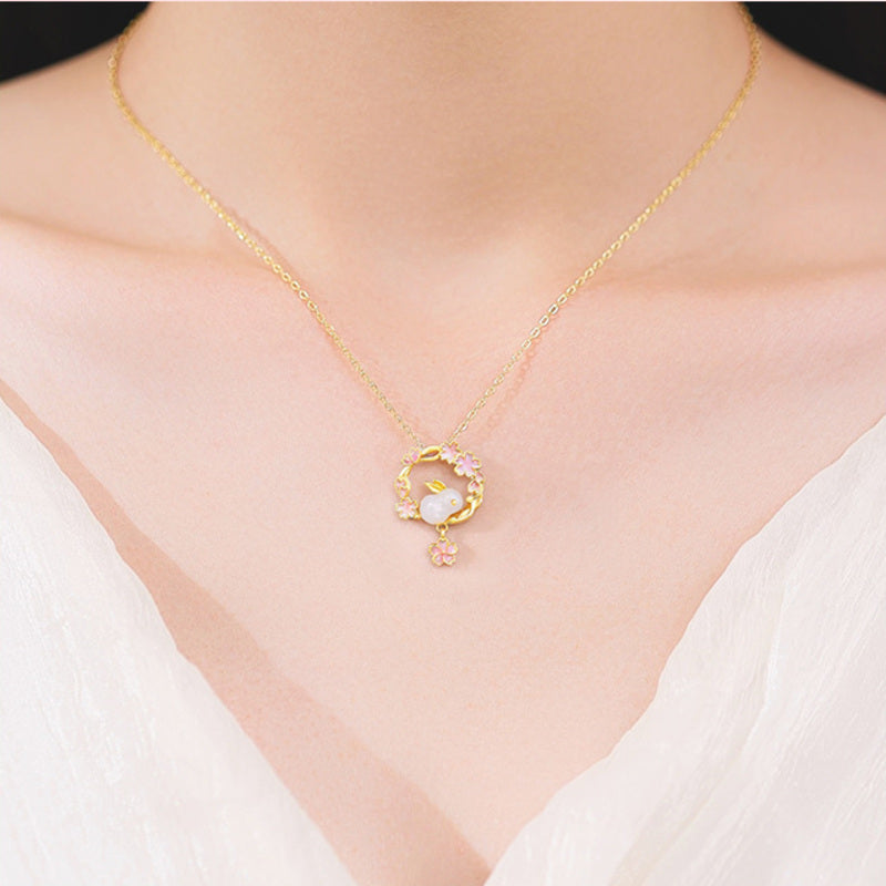 Model wearing delicate nephrite jade rabbit blossom necklace