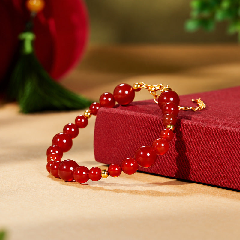 Red agate 925 silver bracelet resting against a red book