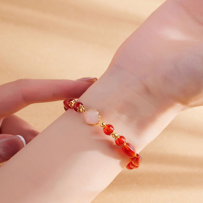 Red agate bracelet worn on wrist in warm light