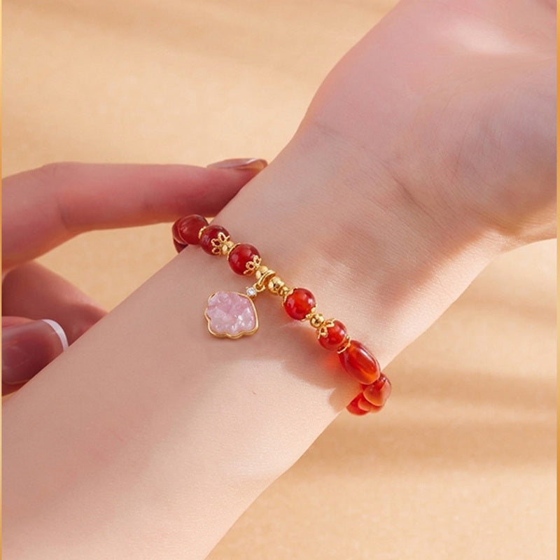Close wrist view of red agate shell charm bracelet