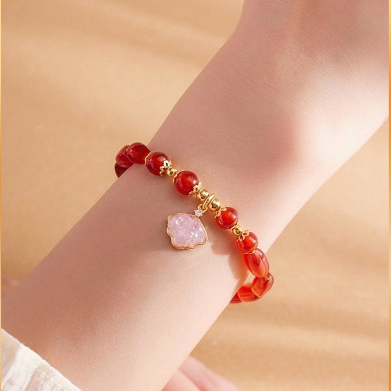 Red agate shell charm bracelet worn on wrist