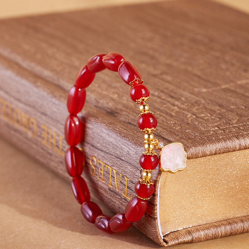 Side view of red agate shell charm bracelet