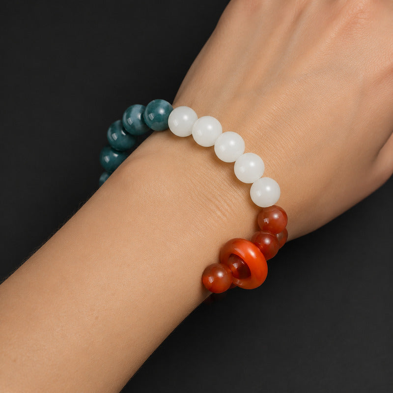 Woman wearing jade bracelet with one Red Agate sliding donut