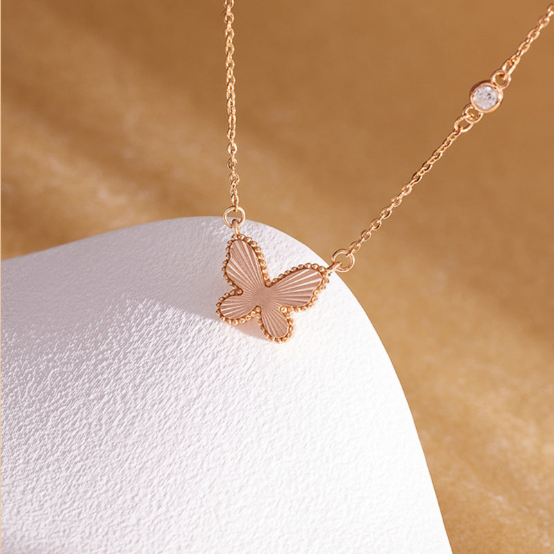 Close view of the champagne-gold-color textured butterfly necklace