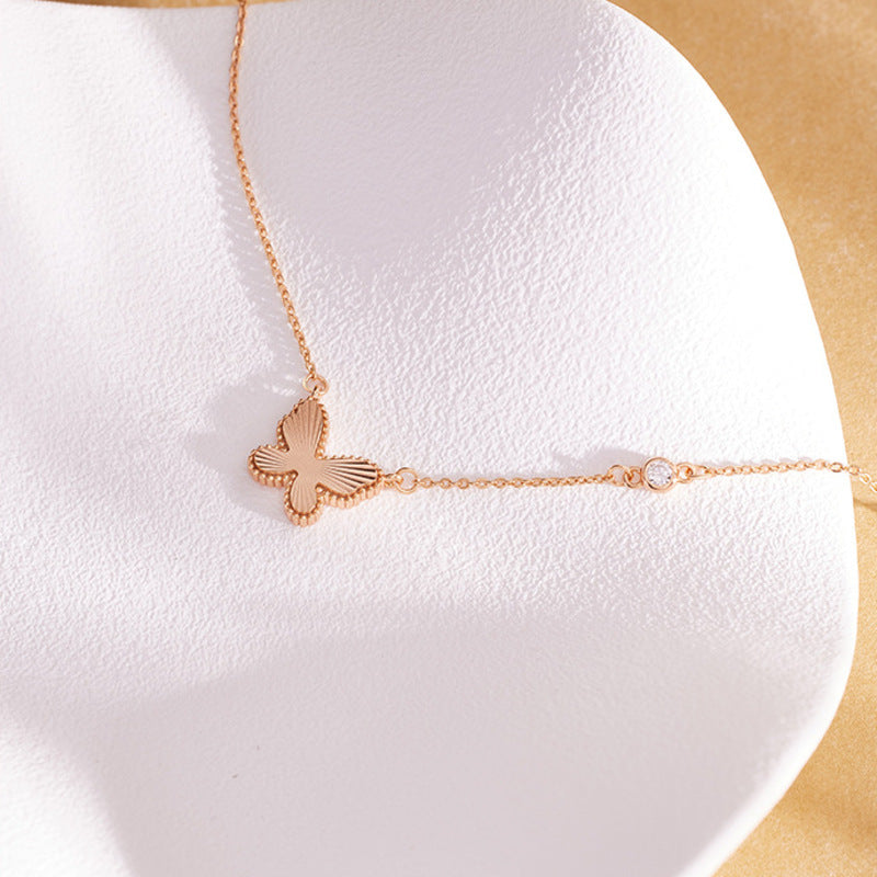 Textured butterfly necklace arranged across a white jewelry display
