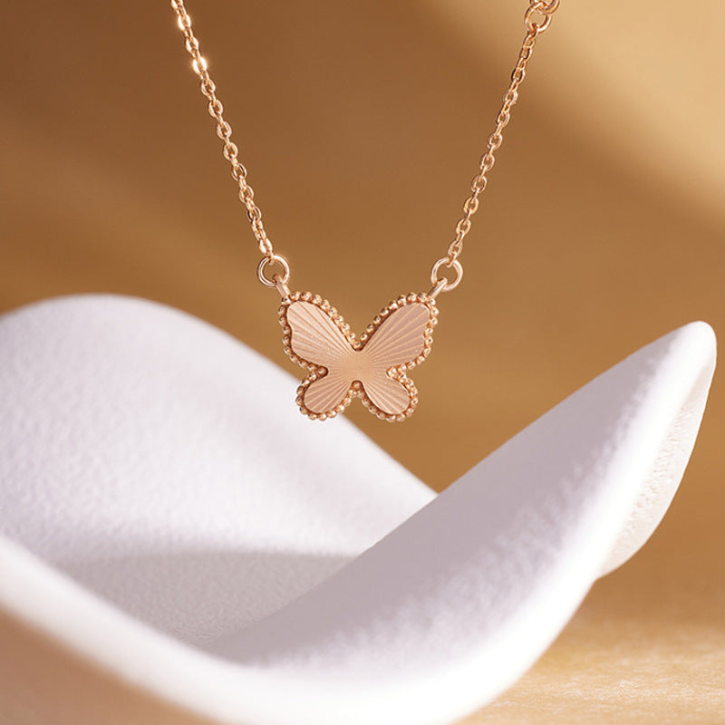 S925 silver textured butterfly necklace on a warm sculptural display