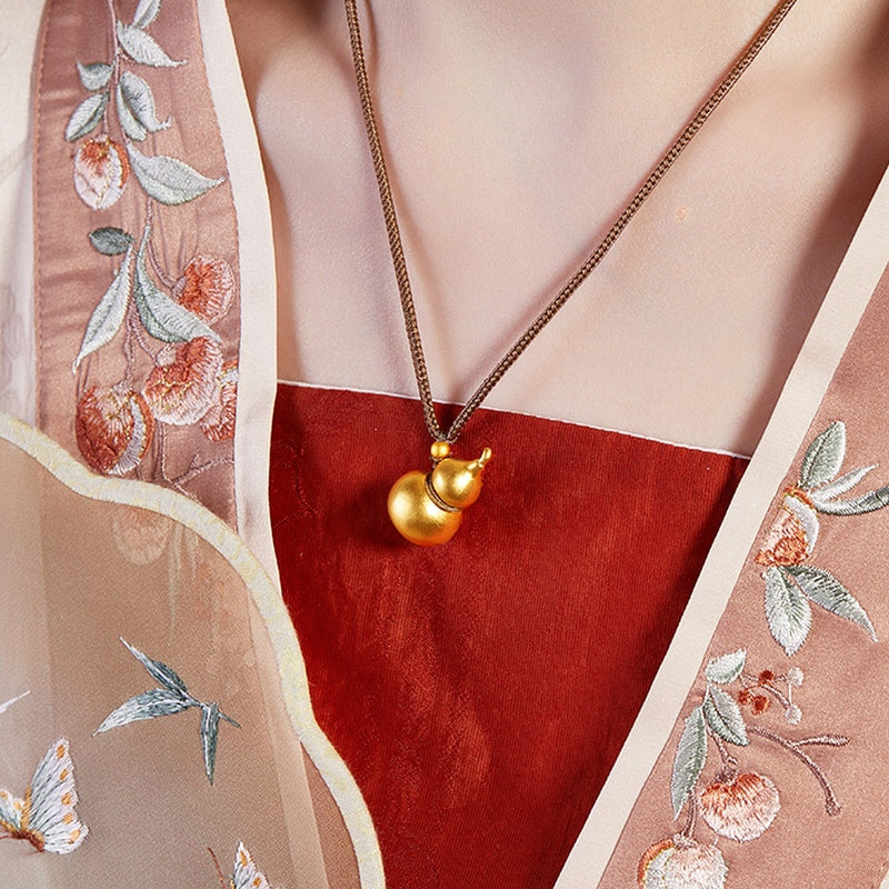 Original model wearing the gourd necklace beside a fan