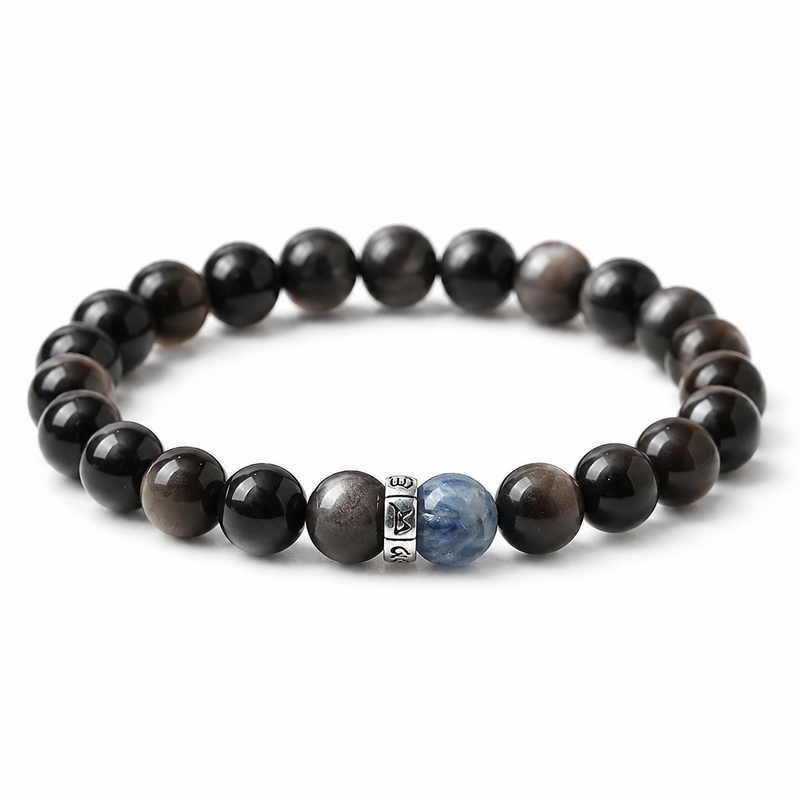 Silver obsidian bracelet with one blue crystal bead and a silver-tone Six-Character Mantra ring on white