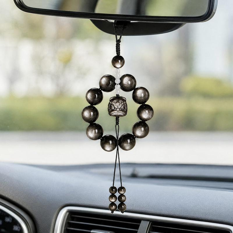Silver obsidian Lion Dance charm hanging from car mirror